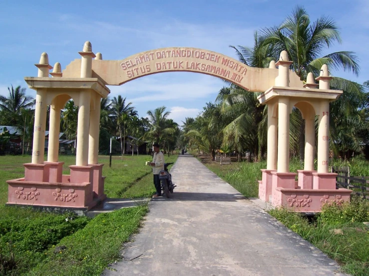 an image of a park entrance with a motorcycle and some trees