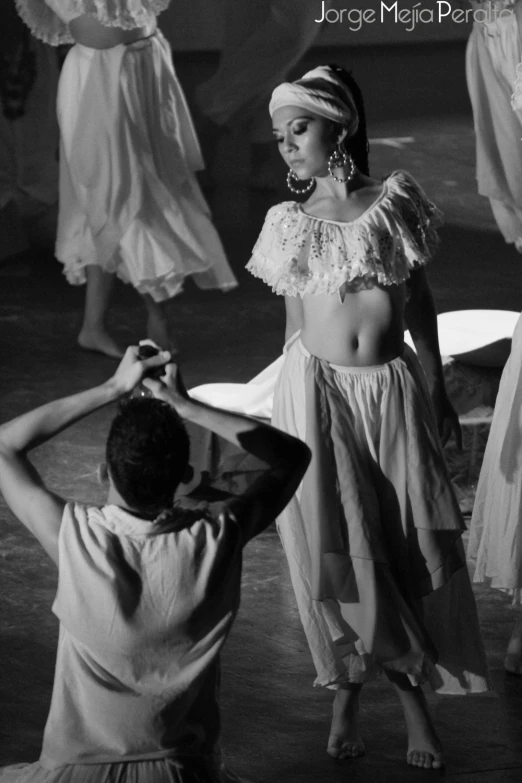 a man adjusts the headband on a woman's chest in an old fashion po