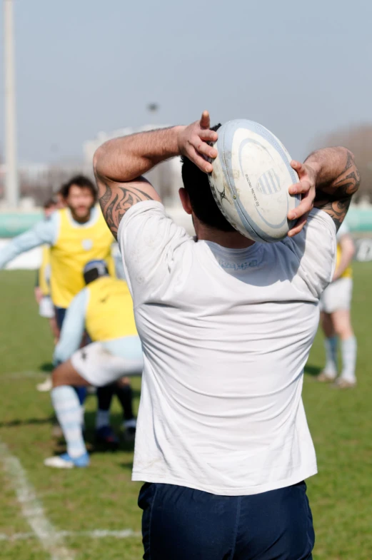 a man holding up a white frisbee standing on top of a field