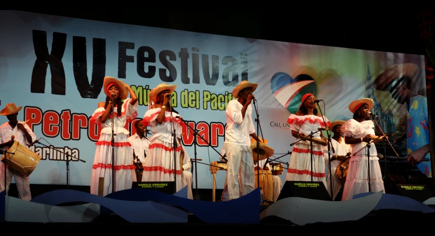 five people in white dresses are standing on stage