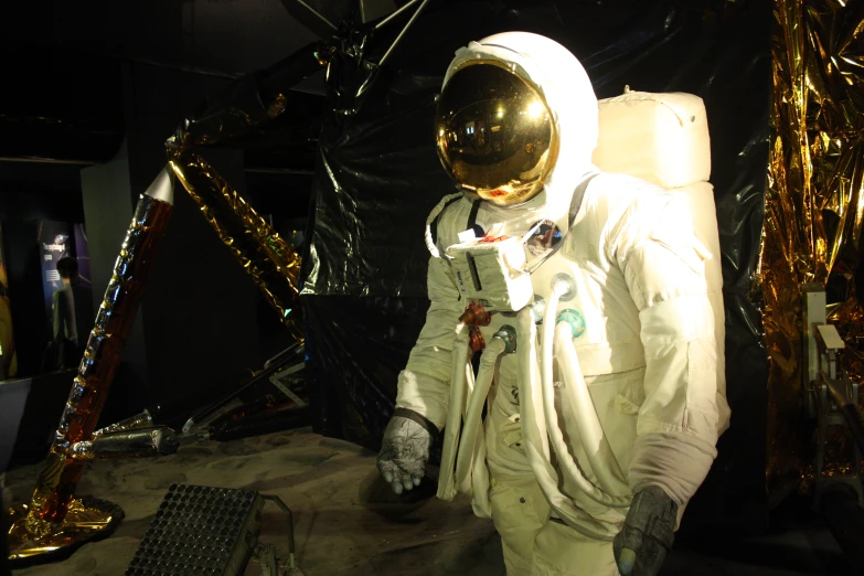 an astronaut in a room with a shiny metal cover