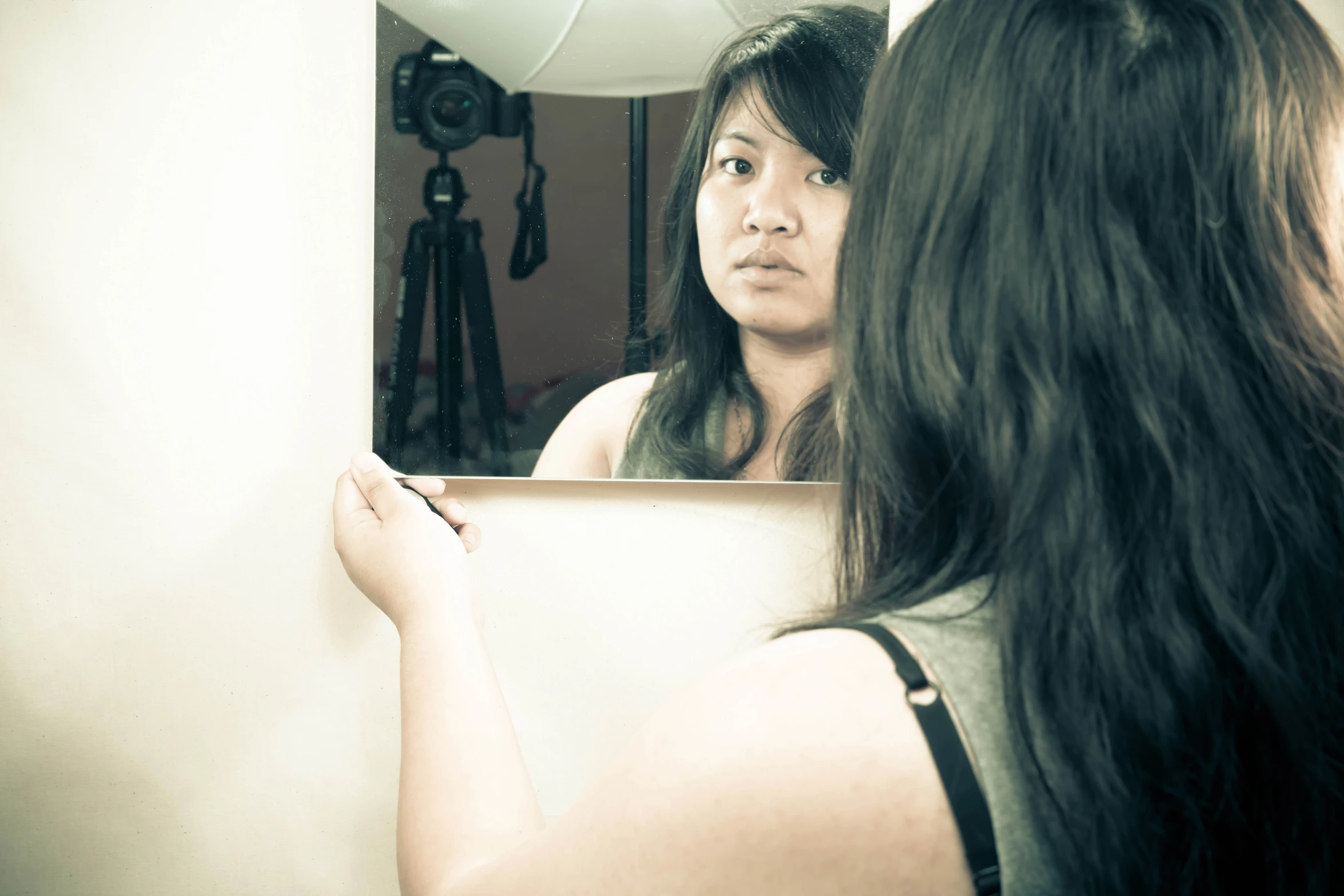 a woman taking a po of herself in the mirror