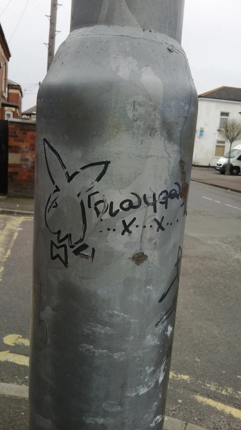 a metal pole with writing and graffitti on it