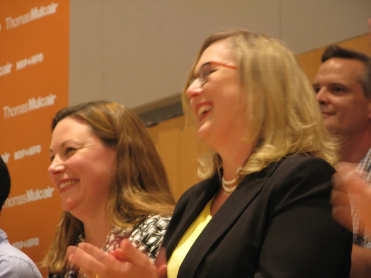 a group of people standing and clapping together