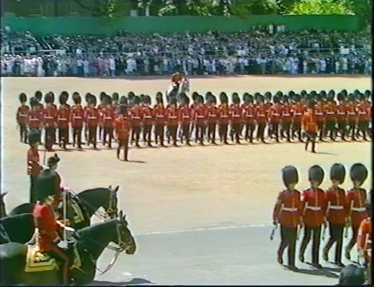 the british military is marching and a lot of people watch