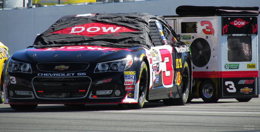 a black and red truck next to a yellow car