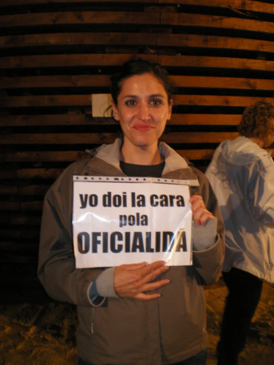 a woman holds up a sign that reads yo doi la caraba nola officialia