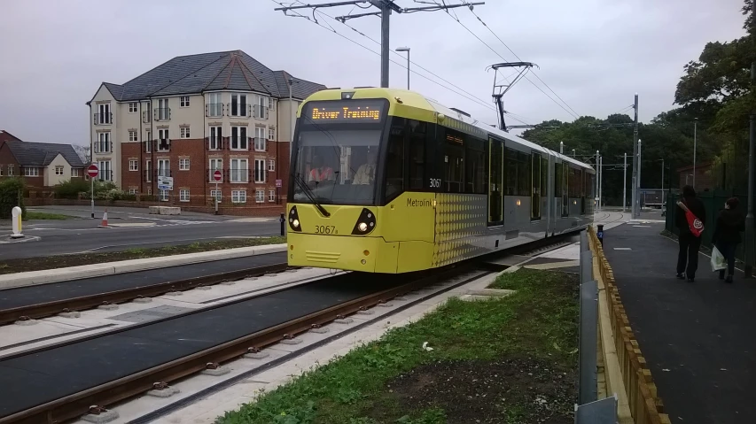 yellow and gray train pulling into a depot