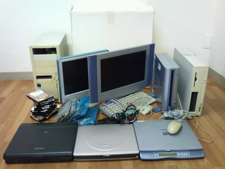 several computer equipment including two monitors, laptops and mouse