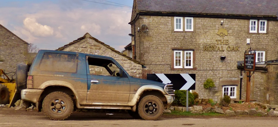 a muddy, brown truck sits near a brick house