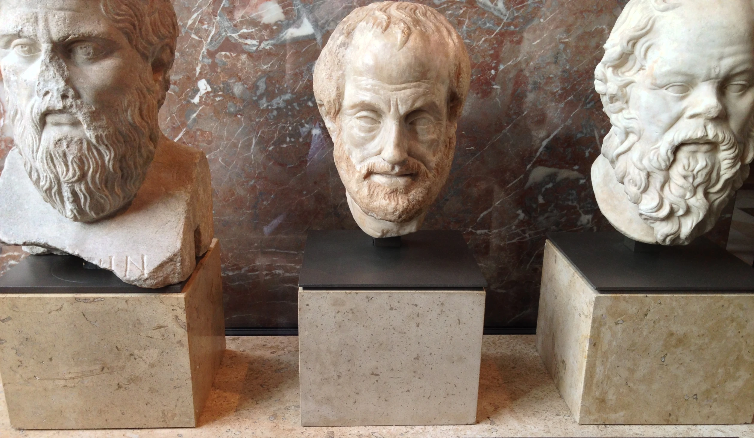 several different busts on display in front of a wall