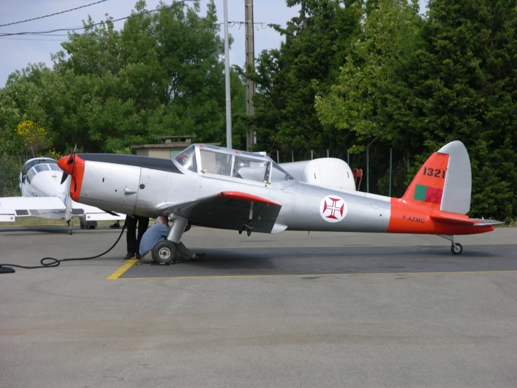 an old propeller plane is being refueled with a propellor