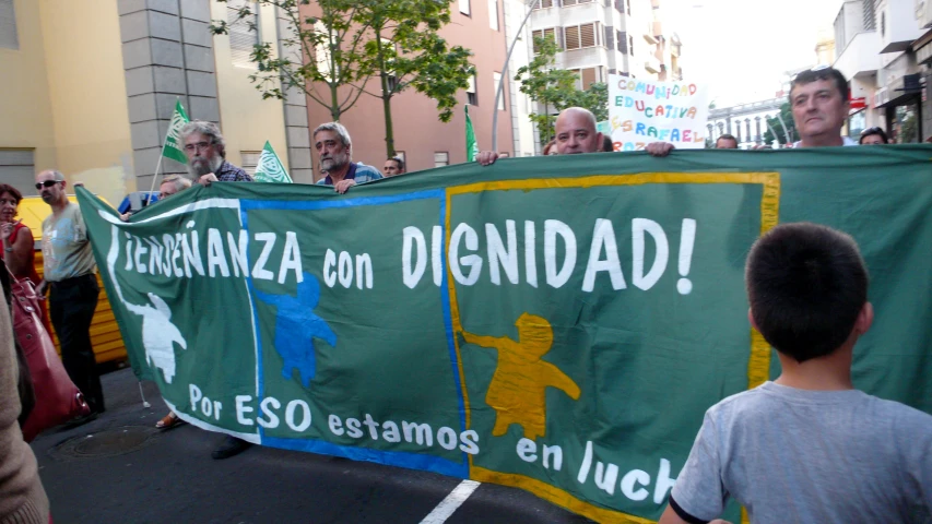 a man standing on top of a street holding a banner