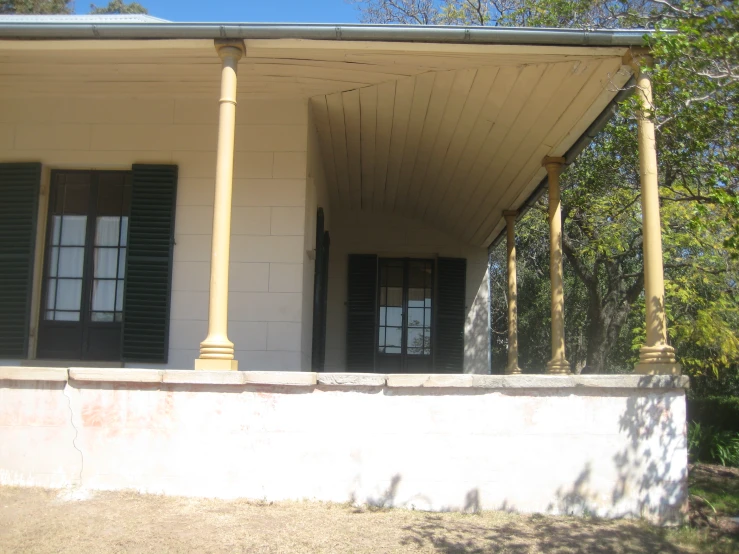 a large house sitting next to two tall trees