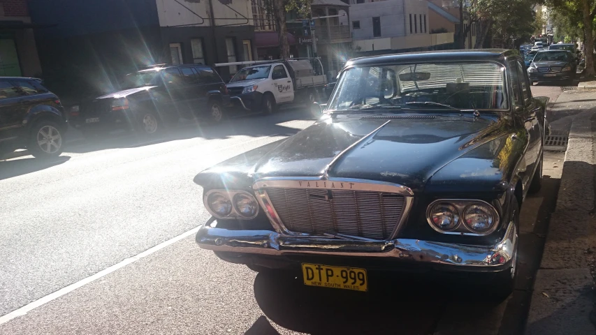 an old car is parked on the side of the road