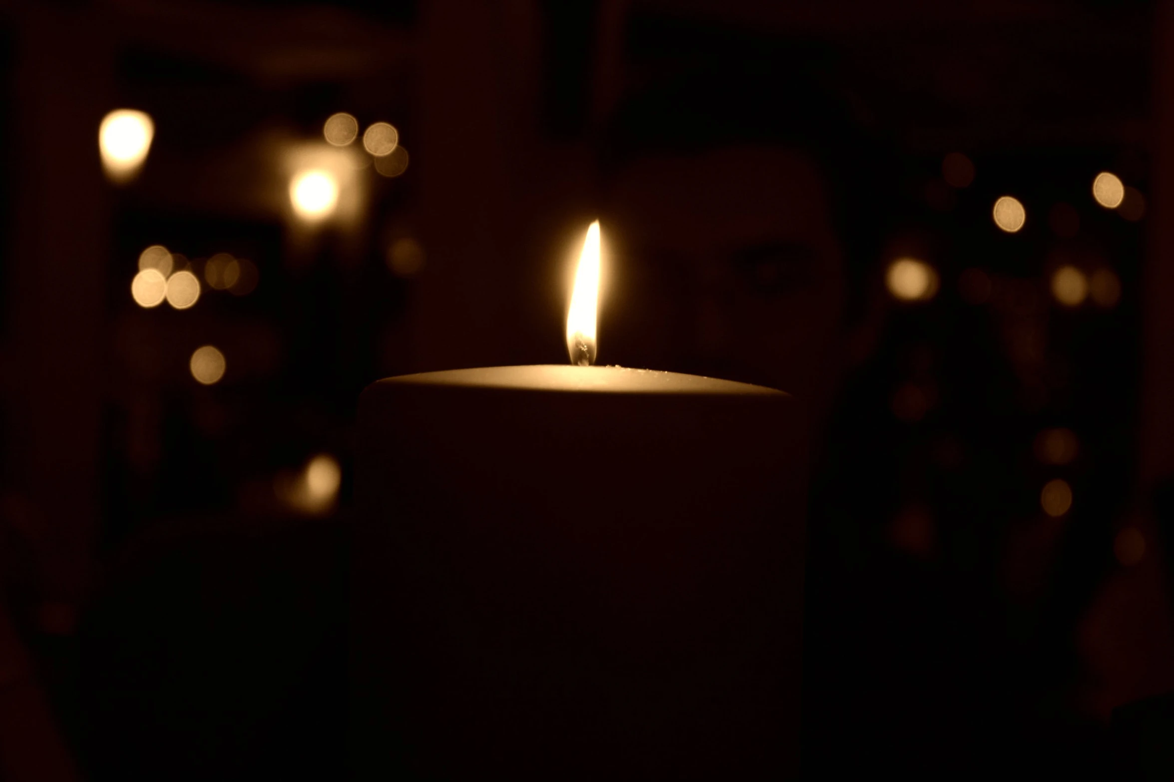 a candle in front of some candles and a person