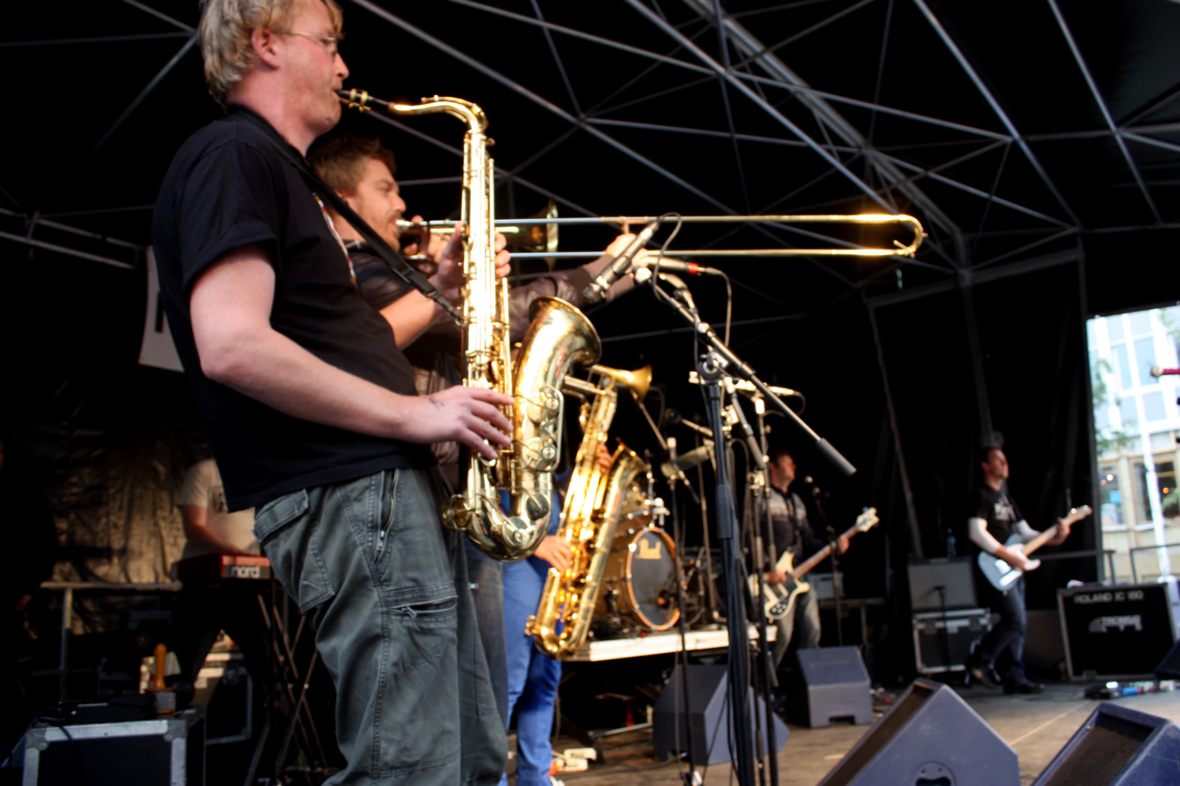 a group of men standing on stage playing saxophone