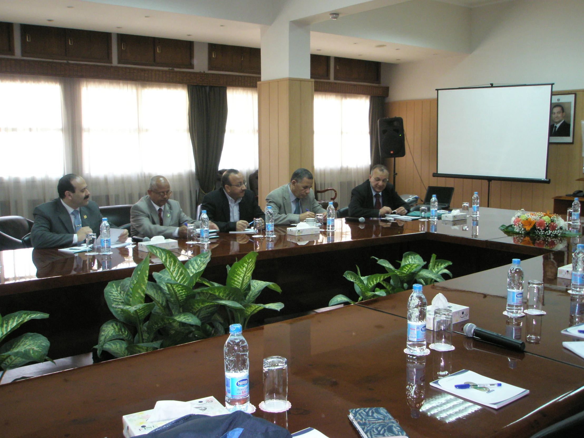 there are many men sitting at a long wooden table