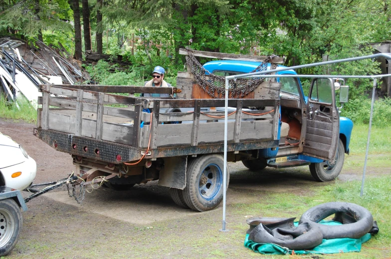 a man driving a truck loaded with lots of junk