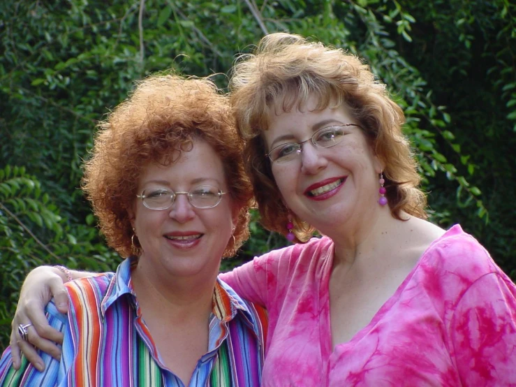 two women are smiling while they pose for the camera