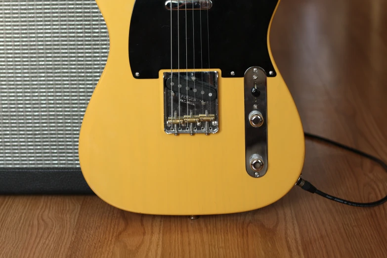 a yellow guitar sitting on a wooden floor