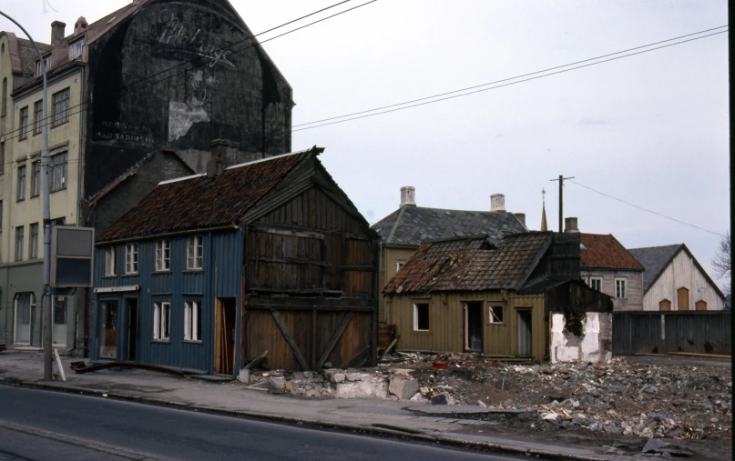 old house next to a street with an arrow going up a hill