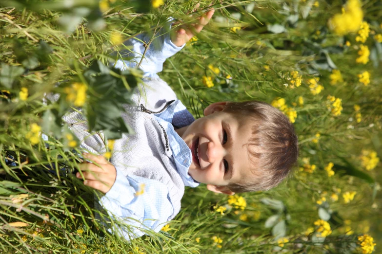 a small child is smiling and standing in the grass