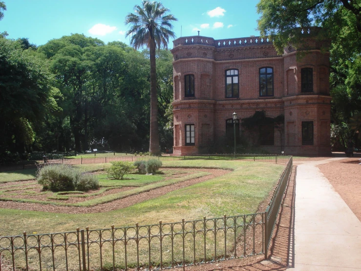 a beautiful brick building with an iron gate in the middle of it