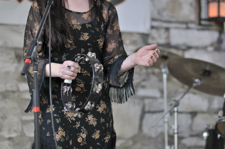 a woman with black hair is holding a microphone