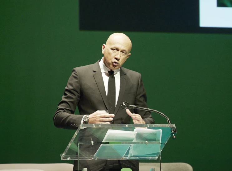 a man in a suit standing at a podium