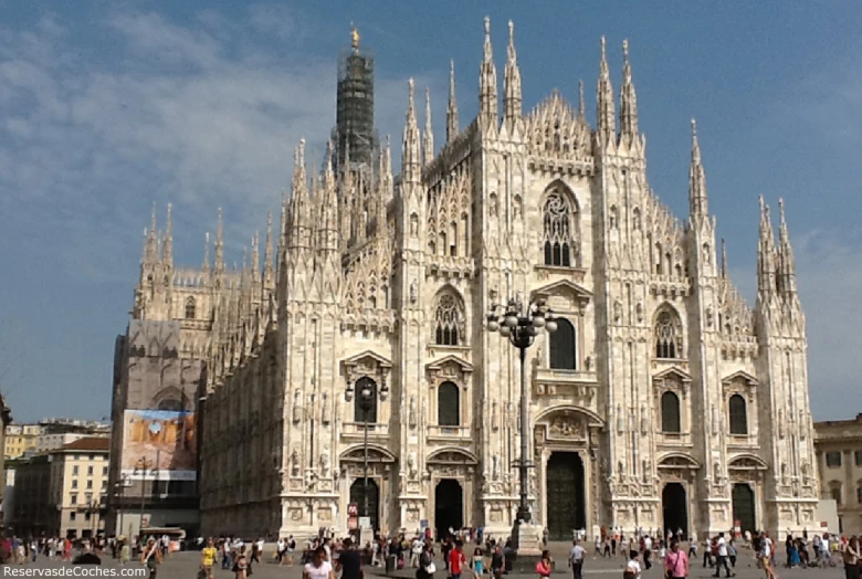 a group of people standing around an architecturally ornate building