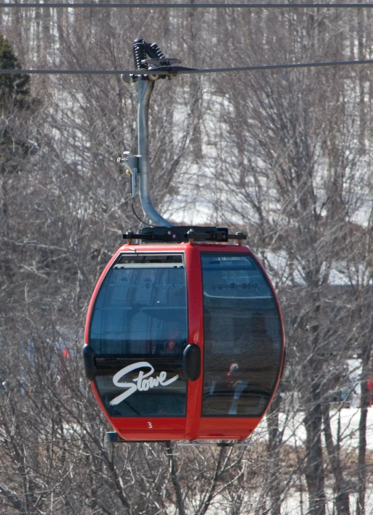 a red cable car on the slopes covered in snow