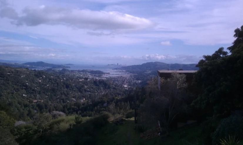 looking out at a lush green hillside with hills and a town