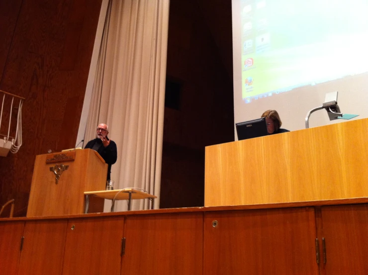 a man at a podium speaking to the public