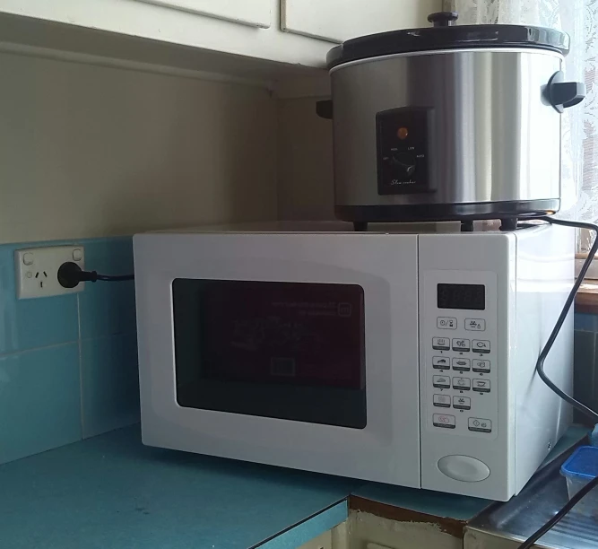 a microwave on a kitchen counter next to a coffee pot