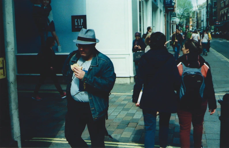 several people on the street are using their cell phones