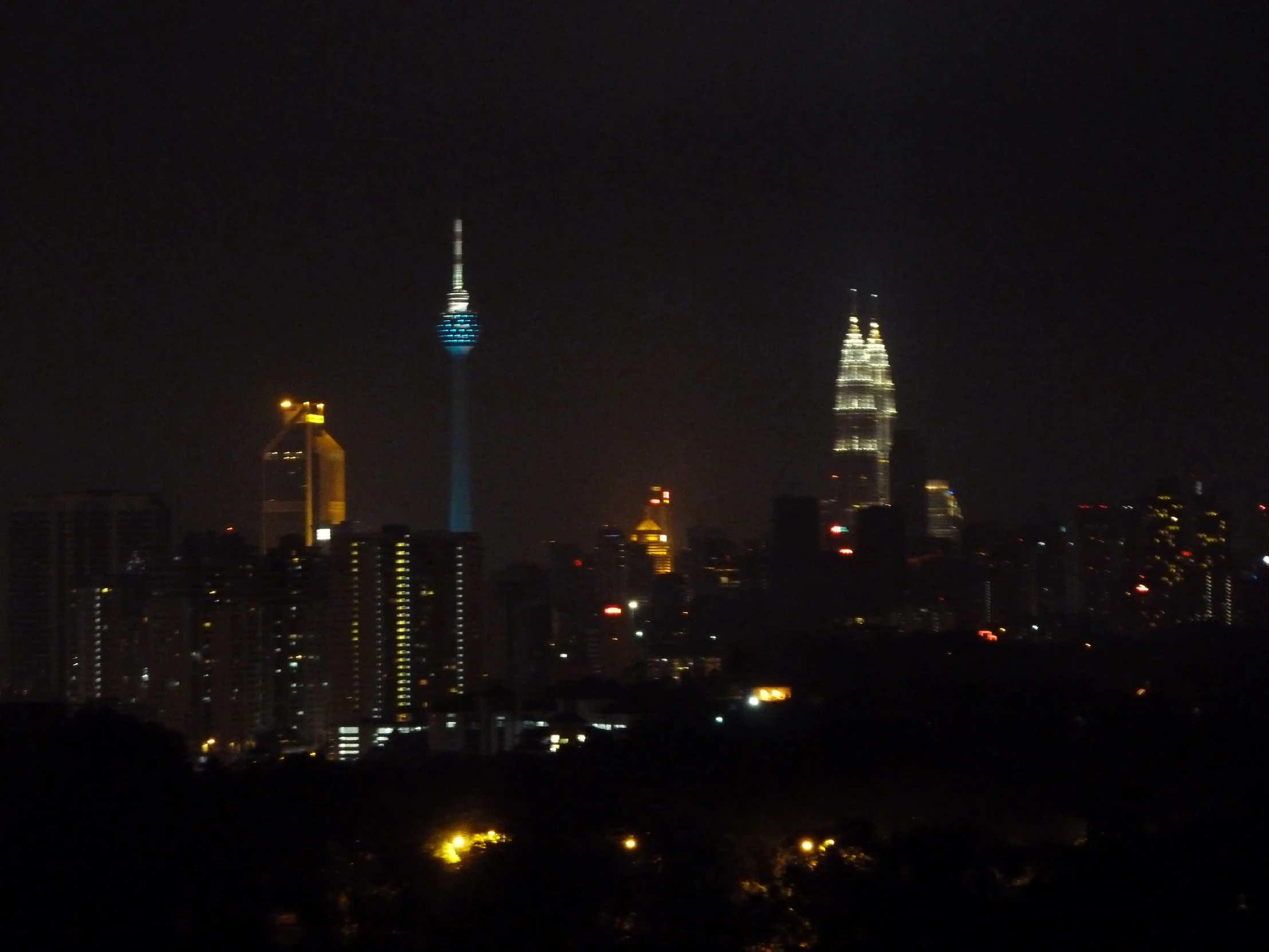 dark city skyline at night with skyscrs and buildings lit up