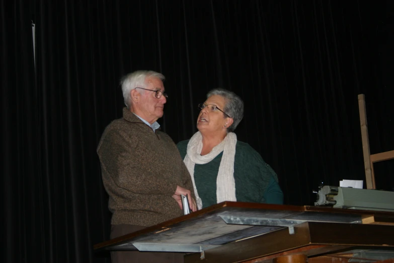 a woman and a man standing next to each other on a stage