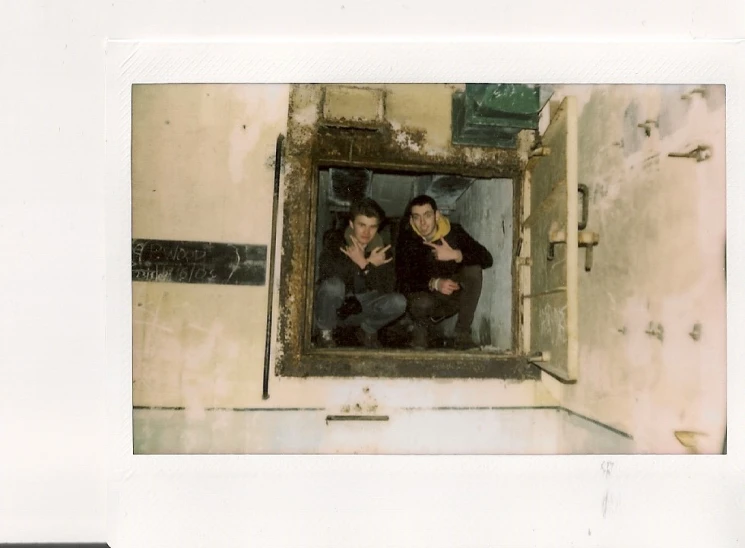 two people are taking a picture in a window