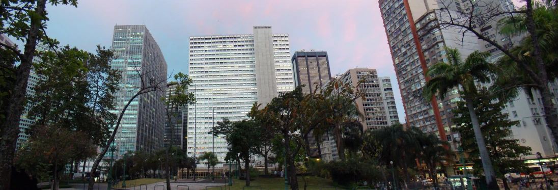 the tall buildings are against a beautiful pink sky