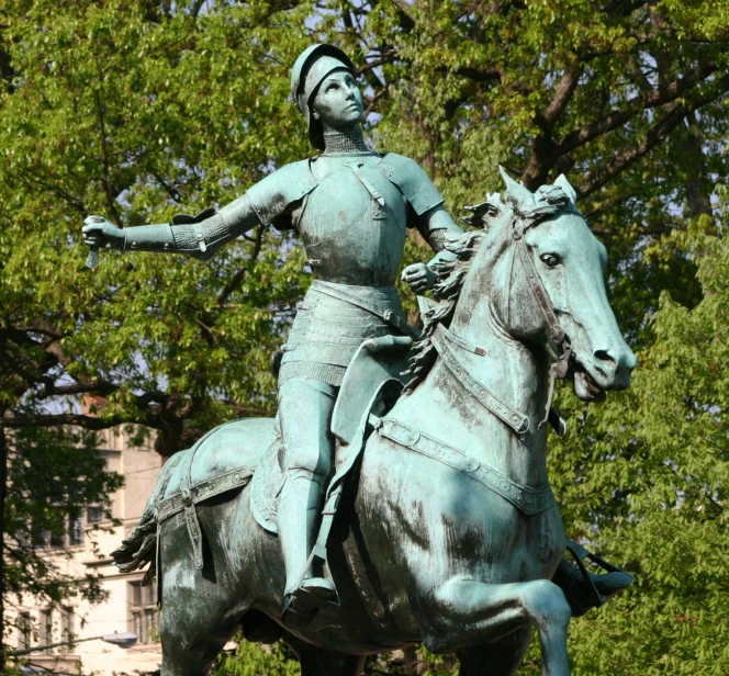 a statue is seen in front of trees