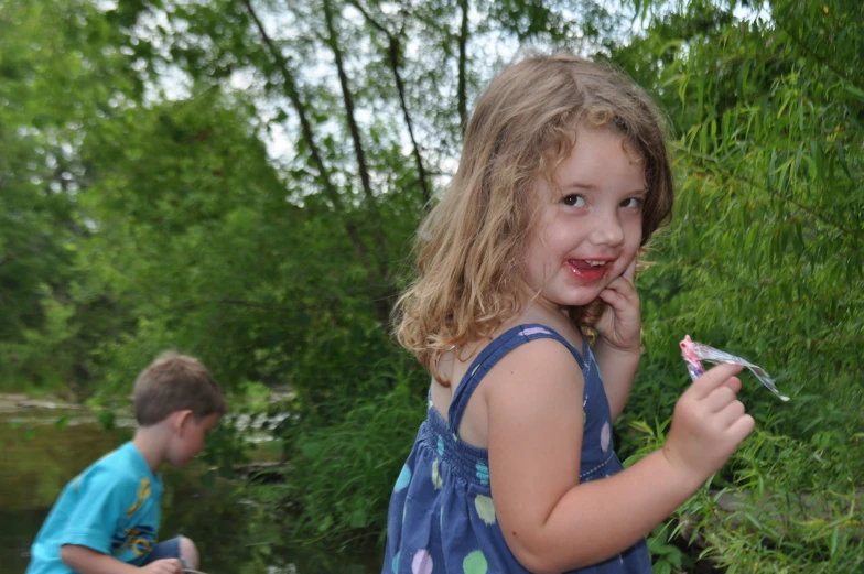 little girl looking at the camera and holding a toothbrush