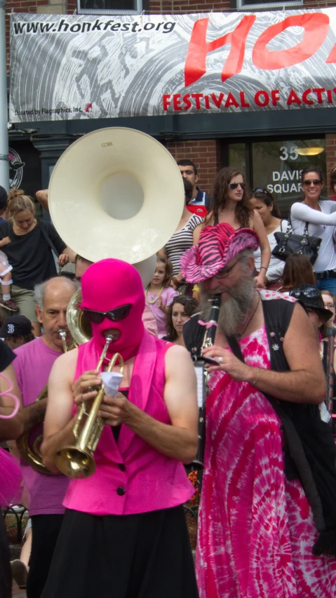 a man in pink outfit holding an old trumpet