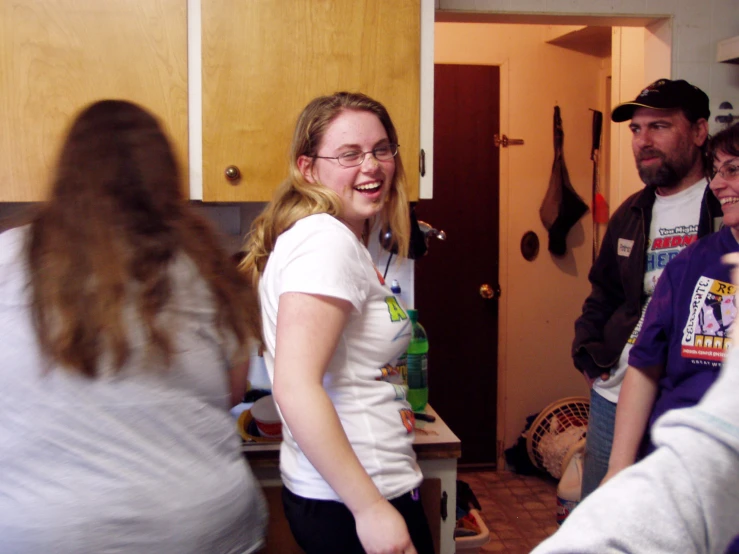 a group of people standing around in a kitchen