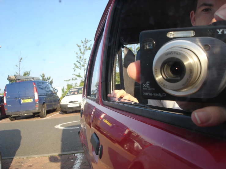 man taking pictures of another person in a car