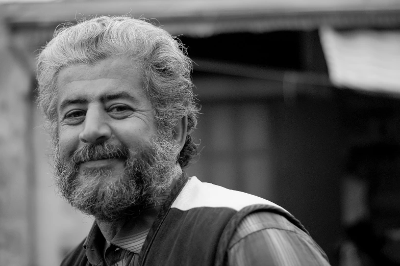 a man with grey hair and beard smiling