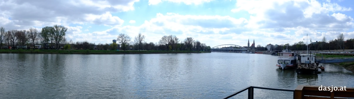 a boat sits in a large river surrounded by green trees