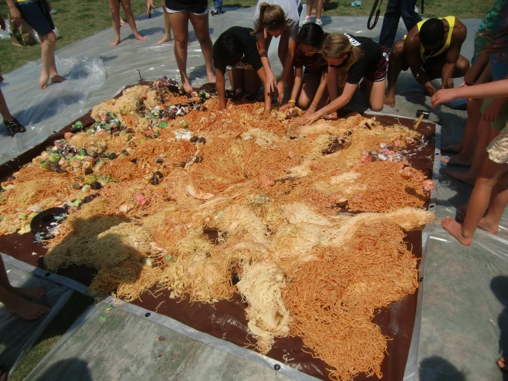 children looking at a huge cake made to look like a world map