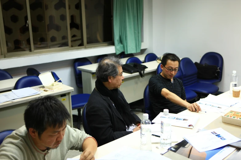 a group of three men sitting at a table