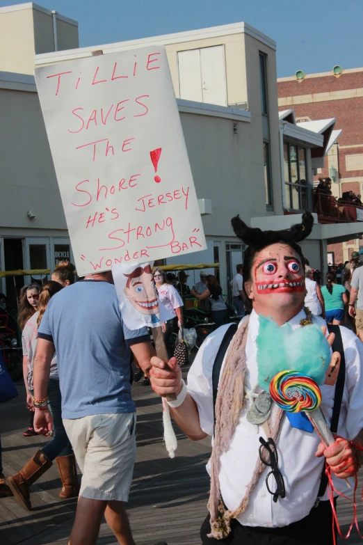 man with face paint holding up signs in a protest